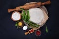 Wooden rolling pin with freshly prepared dough and dusting of flour on dark background Royalty Free Stock Photo