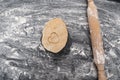 Wooden rolling pin and piece of dough with heart-shaped print. Baking with love. Biscuit making process