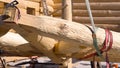 Wooden roof during the early stages of construction in a sunny day. Clip. Bottom view of a builder worker with crane