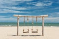 Wooden rope swing on beach in summer