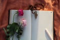 Wooden Rosary, blank notebook, pen and wilted rose flowers on the table. Flat lay concept. Blank open page with Catholic symbol.