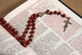 Wooden rosary with a crucifix between the pages of the Bible with the psalm