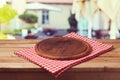 Wooden round board on tablecloth over restaurant background