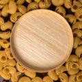 wooden round cup in the middle of italian pasta pepe rigate, snails