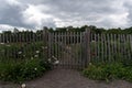 Wooden round rail garden fence in the cloudy day. Royalty Free Stock Photo