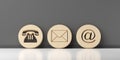 Wooden round telephone, envelope letter and e-mail symbols leaning against dark grey wall background, contact us symbols or banner Royalty Free Stock Photo