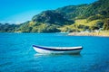 A wooden row boat moored in calm waters of the bay on a glorious summer day Royalty Free Stock Photo