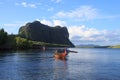 Wooden rowing boat on blue sea water and sun light reflect Royalty Free Stock Photo