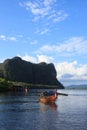 Wooden rowing boat on blue sea water and sun light reflect Royalty Free Stock Photo