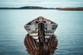 Wooden rowing boat with reflection in a still lake water.