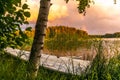 A wooden rowing boat at Sunset on the shores of the calm Saimaa lake in Finland under a nordic sky with a rainbow - 2 Royalty Free Stock Photo