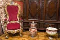 Wooden royal chair with red canvas, two vases and a cabinet made of carved wood, prince`s chair of the 19th century in the interio