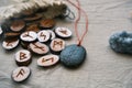 Wooden runes in a canvas bag with a stone runescript