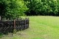 Wooden rural fence in village near the house near the forest. Authentic traditional culture in architecture and life. Old wooden Royalty Free Stock Photo