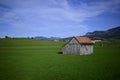 Wooden rural house in the green field Royalty Free Stock Photo