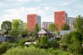 Wooden rural house with outbuildings on the background of beautiful multi-storey buildings of red green white color