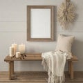 Wooden rustic bench with beige pillow, candles and knitted blanket against wall with blank mock up poster wood frame with copy