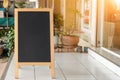 Wooden rustic blackboard in front of restaurant entrance. Mock up Menu Blank Blackboard sign stand Shop Cafe Restaurant. Street Ma Royalty Free Stock Photo