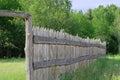 Wooden rustic fence in village near the forest. Authentic traditional culture in architecture and life. Sunlight, old wood