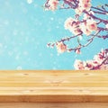 Wooden rustic table in front of spring white cherry blossoms tree Royalty Free Stock Photo