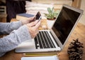 A wooden rustic table with a laptop and a senior people looking at mobile phone.  Outdoor alternative office Royalty Free Stock Photo