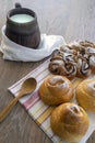 On a wooden rustic table is a large mug of milk and delicious fresh buns. Rustic lifestyle Royalty Free Stock Photo