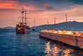 Wooden sailboat on the shore of Saranda port. Amazing spring sunset on Ionian sea. Royalty Free Stock Photo