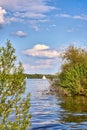 Wooden sailing boat between trees on Lake Schwerin with clouds Royalty Free Stock Photo