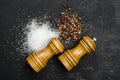 Wooden salt shaker and pepperbox on black chalk board. Royalty Free Stock Photo