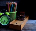 Wooden school pencil case, alarm clock, color pencils, wooden typewriter on an old wooden table. Royalty Free Stock Photo