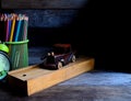 Wooden school pencil case, alarm clock, color pencils, wooden typewriter on an old wooden table. Royalty Free Stock Photo