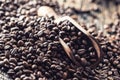 Wooden scoop full of coffee beans on old oak table