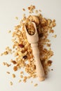 Wooden scoop and granola on white background