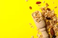 Wooden scoop and granola on yellow background