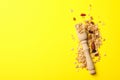 Wooden scoop and granola on yellow background