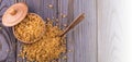 Wooden scoop spoon and bowl full of brown cane sugar with pinch of sugar spilled around on wooden table, top view Royalty Free Stock Photo