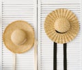 Wooden screen with a straw hat on a background of a white brick wall with copy space. Travel delayed during the coronavirus