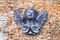 Wooden sculpture of an italian angel against a brick wall Royalty Free Stock Photo