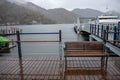 Wooden seat at pier beside Chuzenji lake on misty mountain with fresh autumn trees background