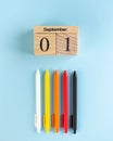 Wooden September 1 calendar, colored pens on a blue background. Art concept of the beginning of the school year