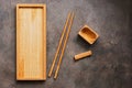 A wooden set of dishes and cutlery Asian cuisine sushi and rolls, a rectangular plate, chopsticks and a bowl for soy sauce on a Royalty Free Stock Photo