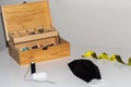 Wooden sewing kit on a white table, with colored thread and needle, with a handmade black facial mask to fight the coronavirus Royalty Free Stock Photo