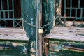 Wooden shabby door locked with padlock. The doors of the old house are locked. Property locked with chain. Royalty Free Stock Photo