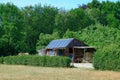 Wooden shack with solarpanels in a field with green trees background Royalty Free Stock Photo