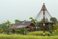 A wooden shack thatched straw and zinc of the rain flows into th