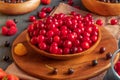 In a wooden shallow bowl there is not fully ripe cherries with drops of water Royalty Free Stock Photo