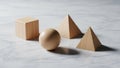 Wooden shapes including a cube sphere and two pyramids are placed on a Royalty Free Stock Photo