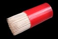 Wooden sharp toothpicks in red plastic container isolated on black macro Royalty Free Stock Photo