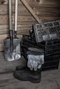 Wooden shed with empty plastic drawers rubber boots and shovel