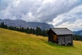 Wooden shed on a grassy meadow in a mountains Royalty Free Stock Photo